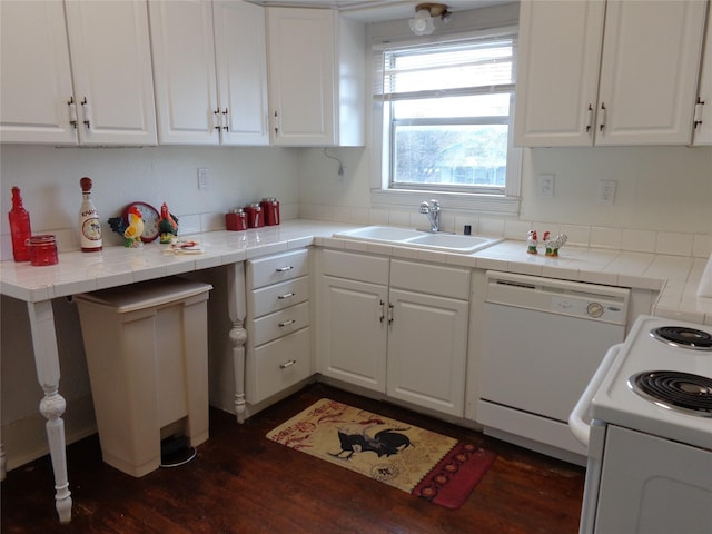 kitchen with stove, white dishwasher, sink, white cabinetry, and tile counters