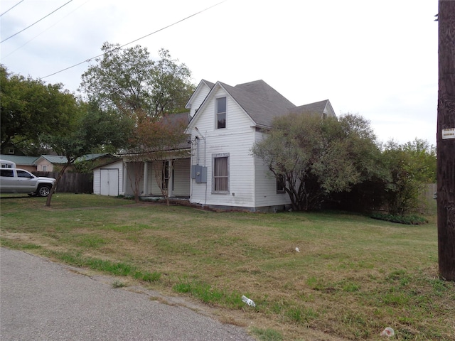 view of side of property with a lawn and a storage unit