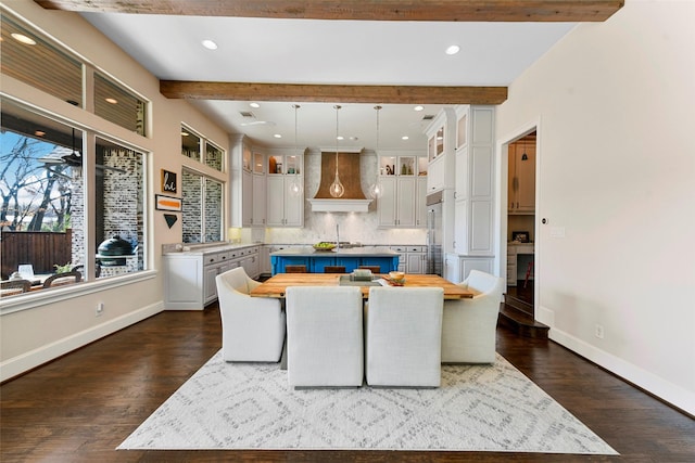 kitchen featuring custom exhaust hood, hanging light fixtures, a center island, butcher block counters, and beamed ceiling