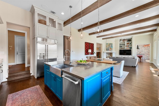 kitchen with stainless steel appliances, white cabinetry, beamed ceiling, built in features, and blue cabinetry