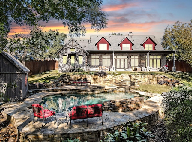 back house at dusk with a patio