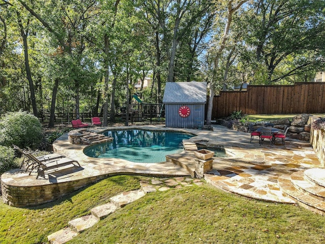 view of swimming pool featuring an outdoor fire pit, a storage unit, and a patio area