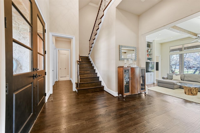 entrance foyer featuring a high ceiling, dark wood-type flooring, and ceiling fan