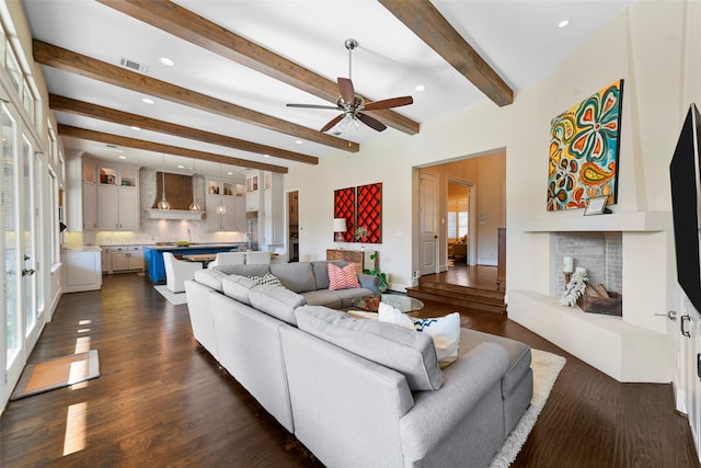 living room featuring ceiling fan, beamed ceiling, and dark wood-type flooring