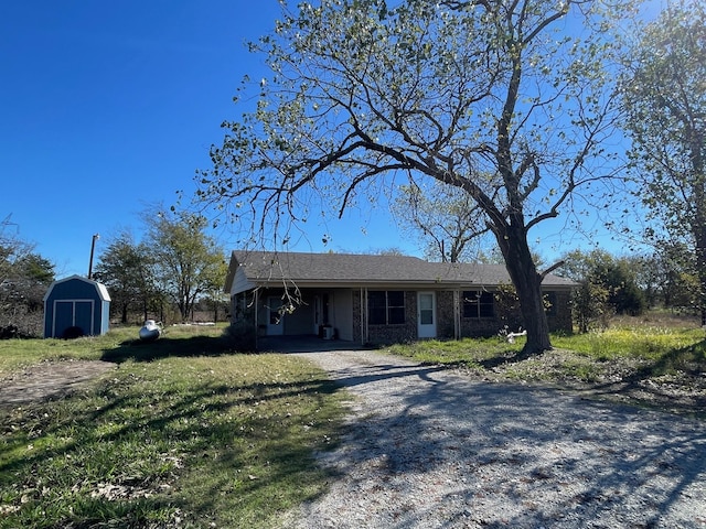 single story home with a storage unit and a front yard