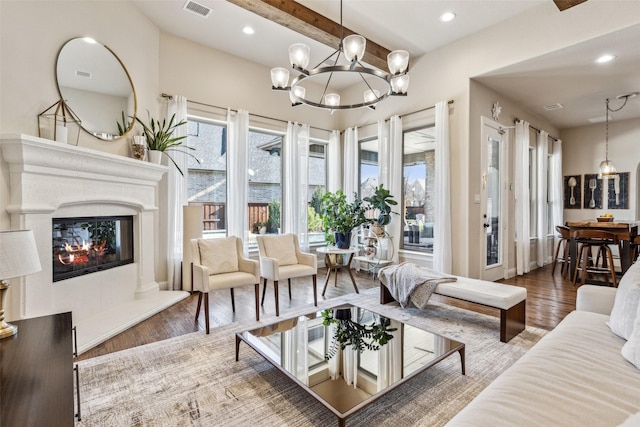 living room with a high end fireplace, visible vents, recessed lighting, and wood finished floors