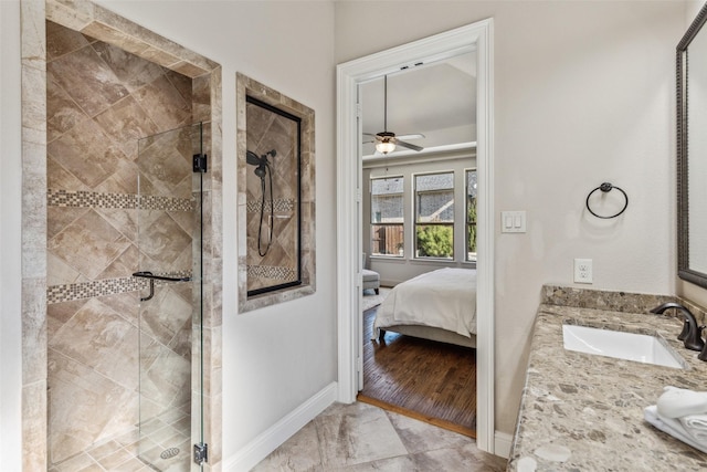 ensuite bathroom featuring baseboards, vanity, a stall shower, and ensuite bathroom