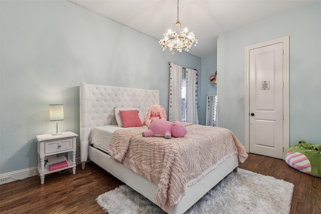 bedroom featuring a notable chandelier, baseboards, and wood finished floors