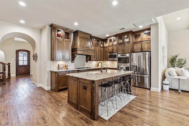 kitchen with a sink, visible vents, appliances with stainless steel finishes, and custom range hood