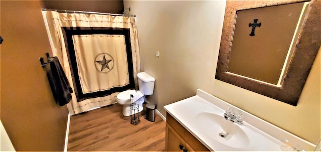 bathroom with hardwood / wood-style flooring, vanity, and toilet