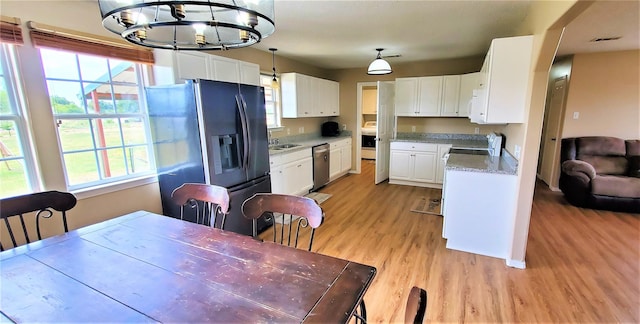 kitchen with black refrigerator with ice dispenser, stainless steel dishwasher, decorative light fixtures, an inviting chandelier, and white cabinets