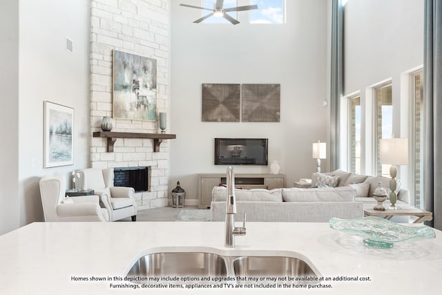 living room featuring a stone fireplace and ceiling fan