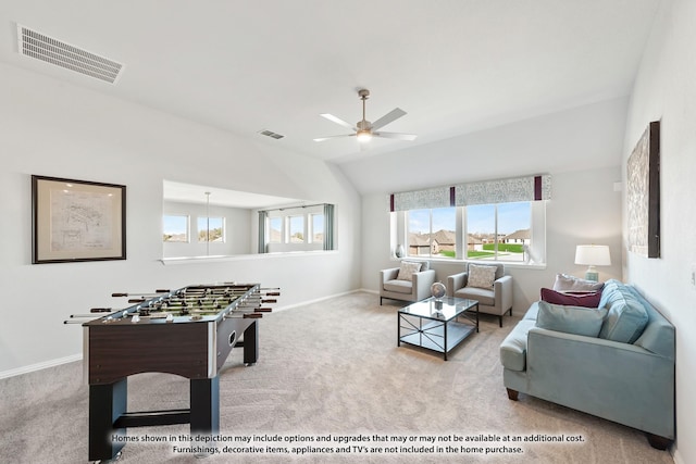 living room with ceiling fan with notable chandelier, light colored carpet, and vaulted ceiling