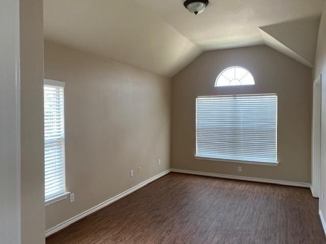 unfurnished room with dark wood-type flooring and lofted ceiling