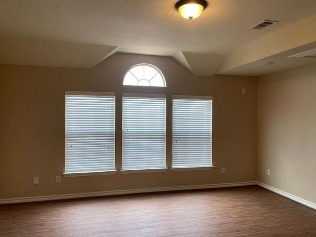 empty room with lofted ceiling and hardwood / wood-style flooring