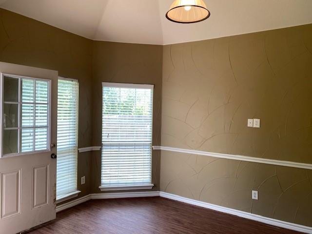 unfurnished room with dark hardwood / wood-style flooring and vaulted ceiling