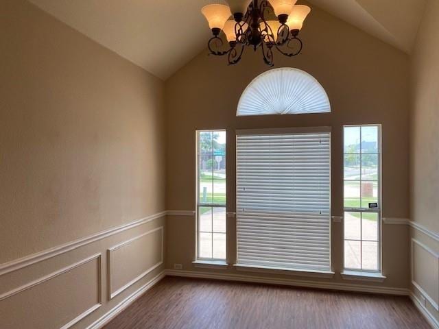 interior space featuring hardwood / wood-style floors, lofted ceiling, and a notable chandelier