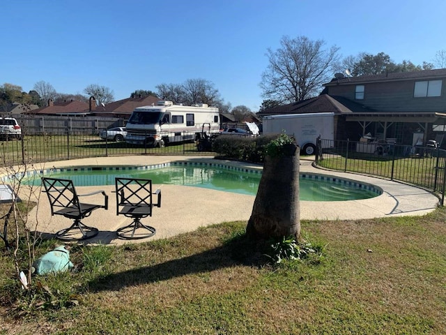 view of swimming pool featuring a yard