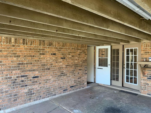 view of exterior entry with a patio