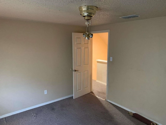 carpeted empty room with a textured ceiling