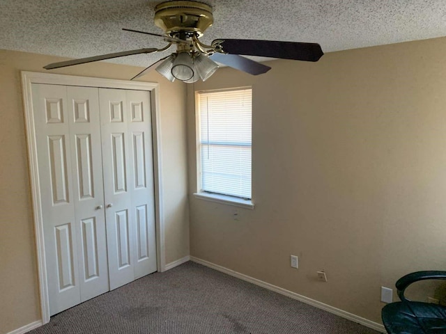 unfurnished bedroom featuring carpet, a textured ceiling, a closet, and ceiling fan