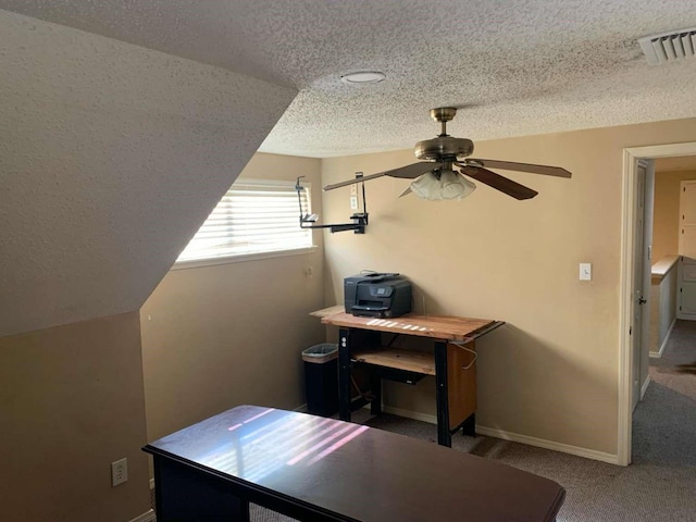 carpeted home office featuring lofted ceiling, ceiling fan, and a textured ceiling