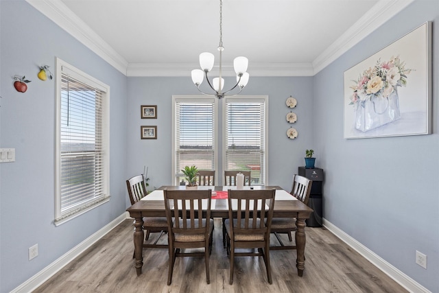 dining space featuring hardwood / wood-style flooring, a notable chandelier, and crown molding