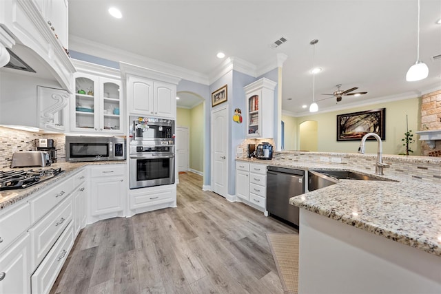 kitchen featuring appliances with stainless steel finishes, backsplash, sink, decorative light fixtures, and white cabinetry