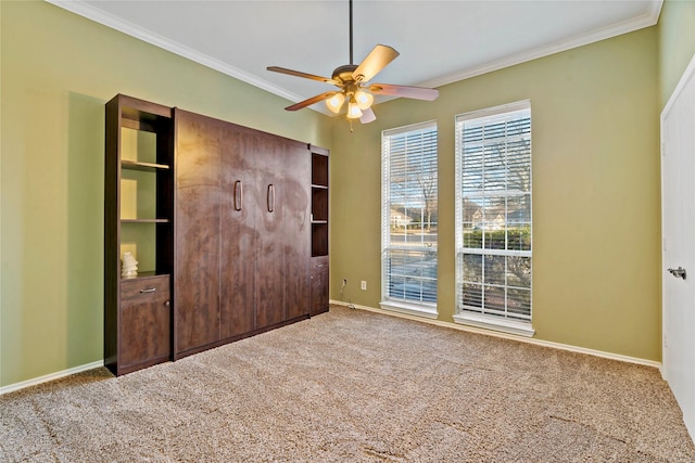 unfurnished bedroom featuring carpet flooring, ceiling fan, and ornamental molding