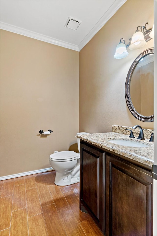 bathroom with crown molding, vanity, and toilet