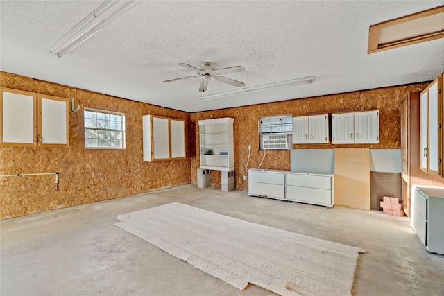 interior space featuring ceiling fan, cooling unit, and a textured ceiling