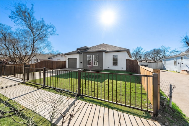 view of front of property featuring a garage and a front lawn