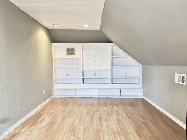 bonus room with vaulted ceiling and light hardwood / wood-style flooring