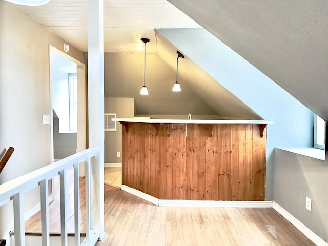 interior space with hardwood / wood-style flooring, pendant lighting, and vaulted ceiling