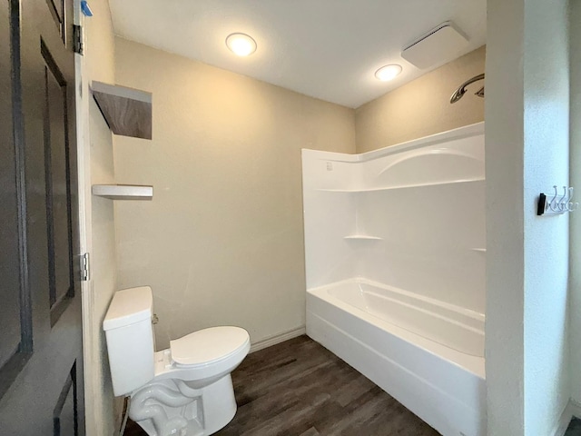 bathroom featuring shower / bathtub combination, hardwood / wood-style flooring, and toilet