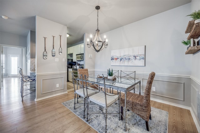 dining room with a notable chandelier and light wood-type flooring