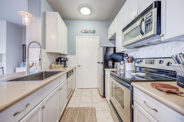 kitchen featuring hanging light fixtures, white cabinetry, sink, and stainless steel appliances