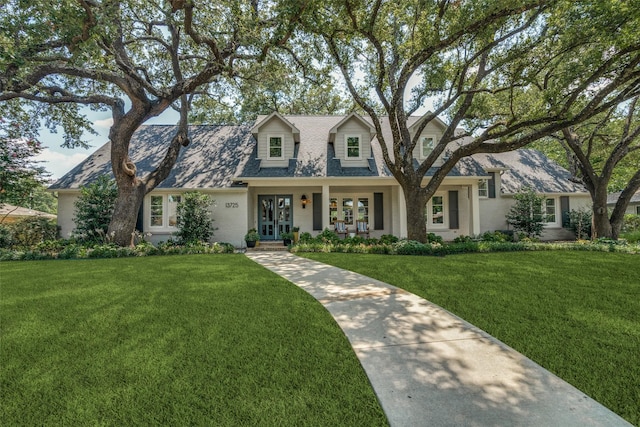 new england style home featuring a porch and a front yard