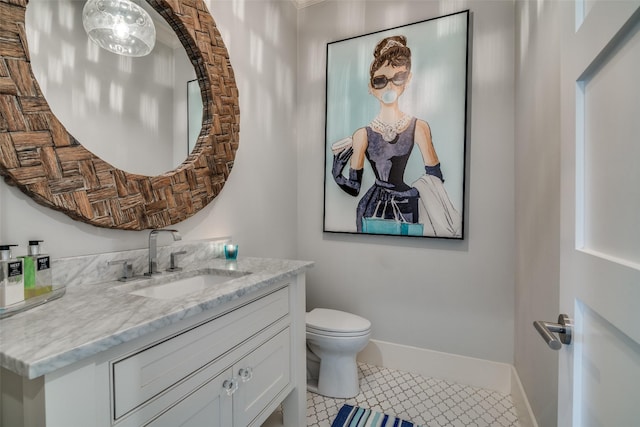 bathroom with toilet, vanity, and tile patterned floors