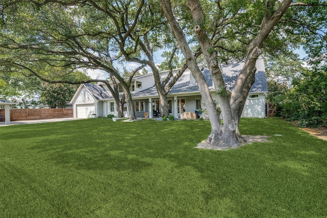 view of front facade featuring covered porch, a garage, and a front yard