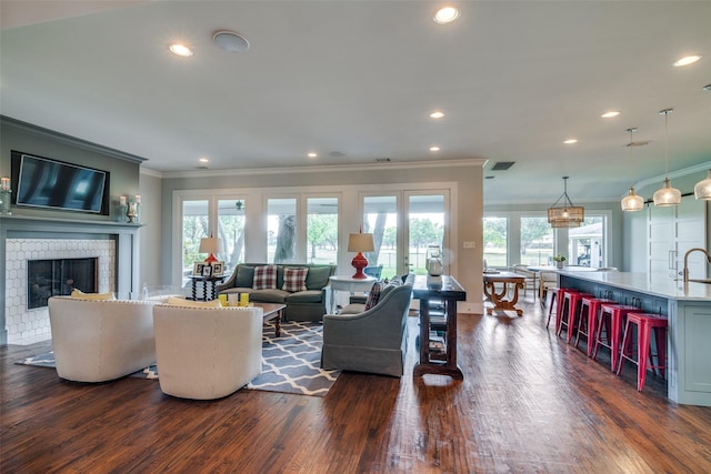 living room featuring dark hardwood / wood-style flooring, ornamental molding, french doors, and a brick fireplace