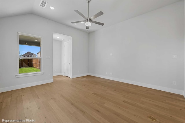 empty room with ceiling fan, light hardwood / wood-style flooring, and vaulted ceiling