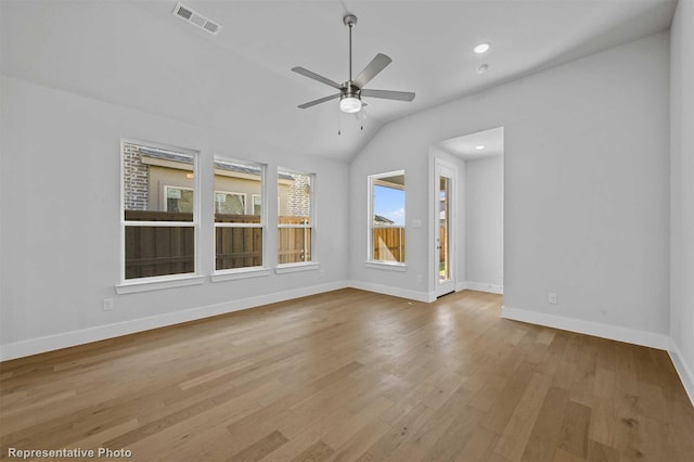 spare room featuring ceiling fan, light wood-type flooring, and lofted ceiling