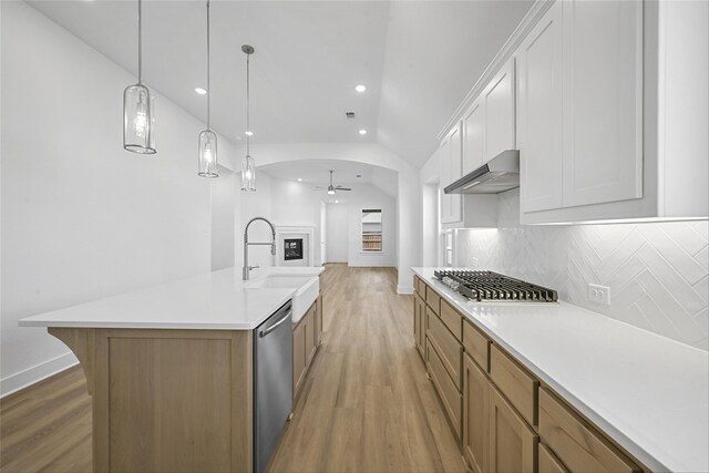 kitchen with light stone countertops, sink, pendant lighting, and white cabinets