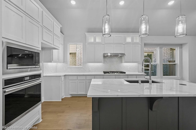 kitchen with white cabinets, hanging light fixtures, and appliances with stainless steel finishes