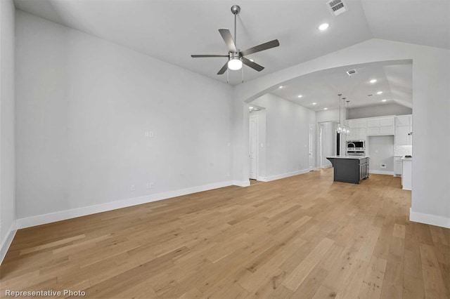 unfurnished living room featuring ceiling fan, lofted ceiling, and light wood-type flooring