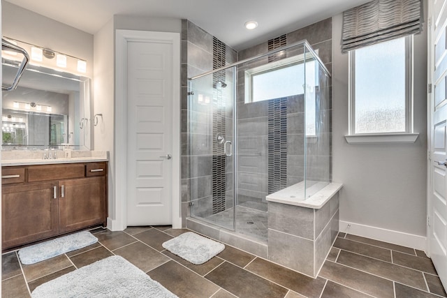 bathroom with an enclosed shower, vanity, and plenty of natural light