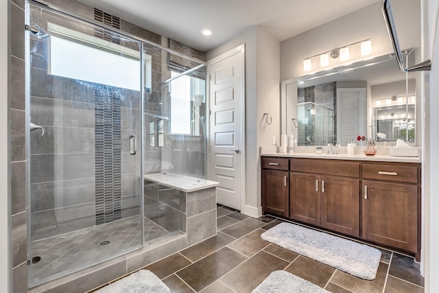 bathroom with tile patterned floors, a shower with door, and vanity