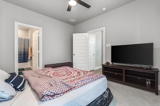 bedroom featuring carpet flooring, ensuite bath, and ceiling fan