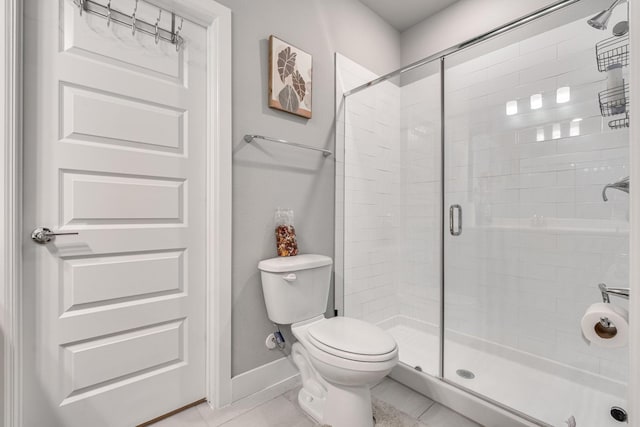 bathroom with tile patterned flooring, toilet, and an enclosed shower